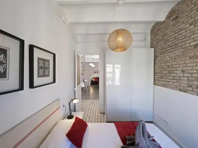 a bedroom with a bed and a brick wall at Sunny Rooftop Apartment in Barcelona