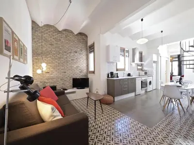 a living room with a couch and a kitchen at Sunny Rooftop Apartment in Barcelona