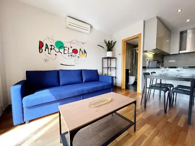 a living room with a blue couch and a table at Teatro Miro Apartment in Barcelona