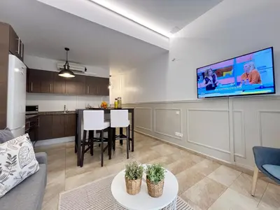 a living room with a couch and a tv on a wall at Torre de Gracia Barcelona in Barcelona