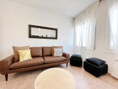 a living room with a brown couch and a table at Villa Olimpica Beach in Barcelona
