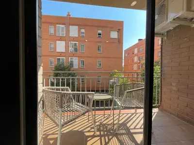 a balcony with chairs and a table and a building at Superflat near beach 15' center in Sant Adria de Besos