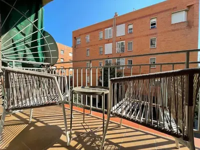 a balcony with two benches and a building at Superflat near beach 15' center in Sant Adria de Besos