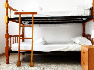 a bedroom with two bunk beds and a desk at AFRODITA Casa con dos apartamentos independientes in Pineda de Mar