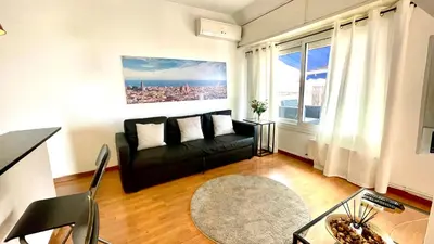 a living room with a table and chairs and a kitchen at Attic Bcn Central Terrace in Barcelona