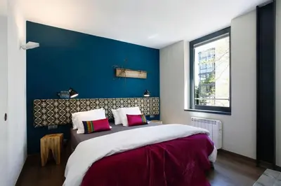 a bedroom with a large bed with a blue wall at Apartment Vila Olímpica Barcelona next to beach & garden in Barcelona