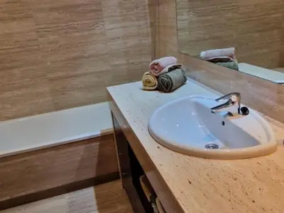 a bathroom with a sink and a mirror and a tub at Homing Sabadell 73 in Sabadell