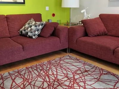 a living room with two purple couches and a rug at Homing Sabadell 73 in Sabadell