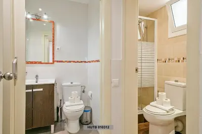 a bathroom with two toilets and a sink and a mirror at Alcam Glorias in Barcelona