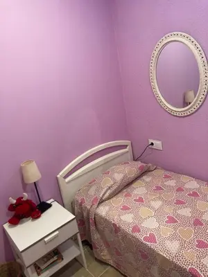 a purple bedroom with a bed and a mirror at Casa con vista y jardín, a 20' de la playa in Sant Cebrià de Vallalta