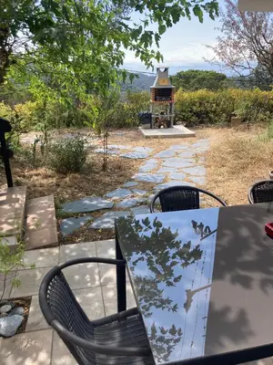 a table and chairs on a patio with a gazebo at Casa con vista y jardín, a 20' de la playa in Sant Cebrià de Vallalta