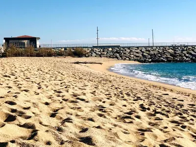 a beach with footprints in the sand next to the water at Apartamento playa in Arenys de Mar