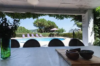 a table with a view of a swimming pool at Wonderful house in the mountains with sea views in Cabrils