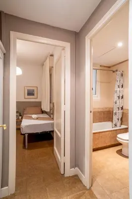 a white bathroom with a shower and a toilet at The Collection Barcelona - Sants Estacio - Modern and comfy 4BD for 8 guests in Barcelona