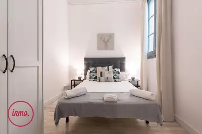 a bedroom with a bed in a white room at Barcelona - Eixample 2 in Barcelona
