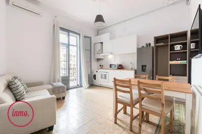 a kitchen and a living room with a table and chairs at Barcelona - Eixample 2 in Barcelona