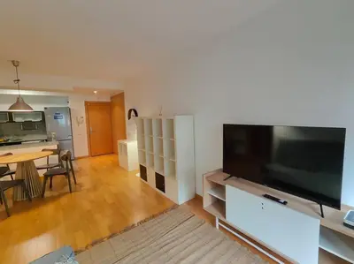 a living room with a large flat screen tv and a table at Cozy apartment Forum beach in Sant Adria de Besos