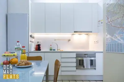 a kitchen with white cabinets and a table with food on it at Bcn - Sagrada Familia in Barcelona