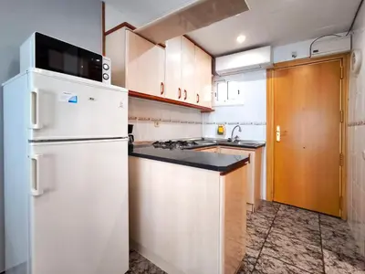 a kitchen with white appliances and a white refrigerator at Apartamento loft en Castelldefels junto la playa in Castelldefels