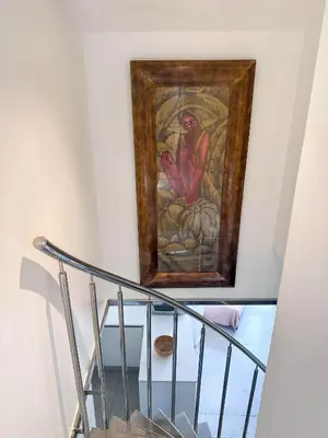 a painting on a wall next to a staircase at Sitges Port View Apartment by Hello Homes Sitges in Sitges