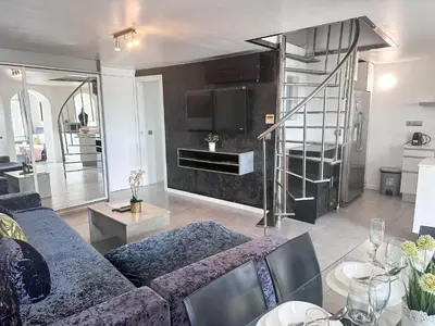 a living room with a blue couch and a kitchen at Sitges Port View Apartment by Hello Homes Sitges in Sitges