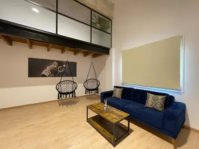 a living room with a blue couch and a table at Manresa industrial home in Manresa