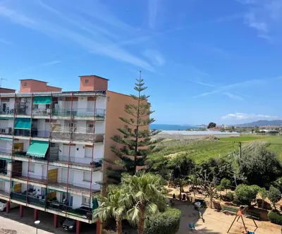 a building with a palm tree in front of it at Apartment Llavaneres near Barcelona Beach Pool in Sant Andreu de Llavaneres