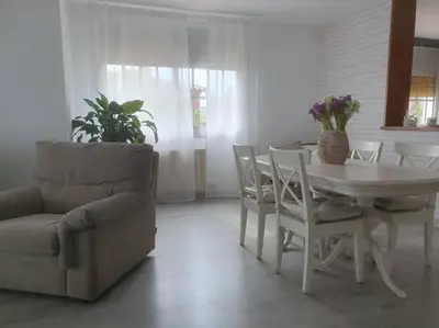 a living room with a table and chairs and a couch at Casa con gran jardín y unas preciosas vistas in Teià
