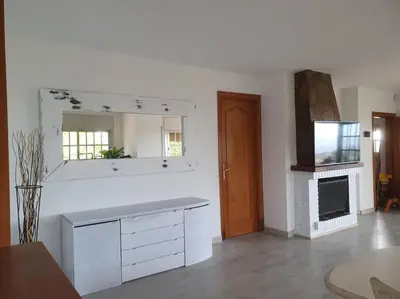 a white room with a fireplace and a mirror at Casa con gran jardín y unas preciosas vistas in Teià