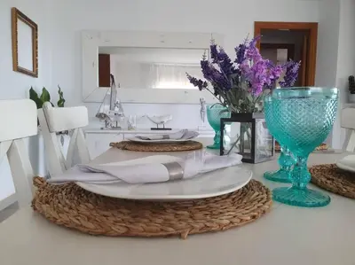 a table with a plate and a vase with purple flowers at Casa con gran jardín y unas preciosas vistas in Teià