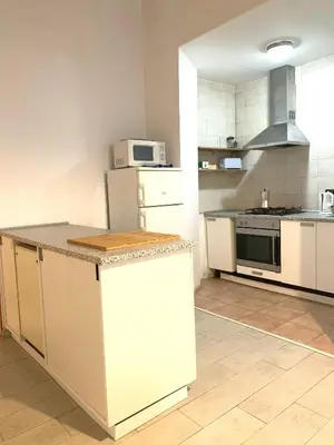 a kitchen with white cabinets and a white microwave at Parallel-Patio in Barcelona