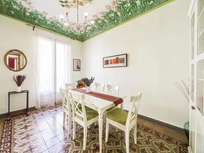 a dining room with a white table and chairs at Belvilla by OYO Rambla Paris Apartment in Barcelona