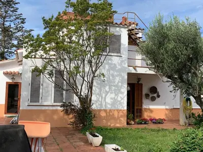 a white house with a tree in front of it at Casa Cal Duc, la Garriga in La Garriga