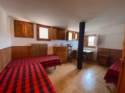 a room with two beds and a kitchen with a stove at Casa Cal Duc, la Garriga in La Garriga