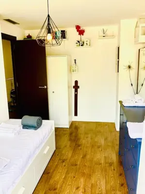 a bedroom with a white bed and a wooden floor at Alma Castellana, Casa en plena Naturaleza in Dosríus