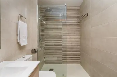 a bathroom with a shower with a toilet and a sink at Space & Privacy Terrace, AC, Central Gràcia in Barcelona