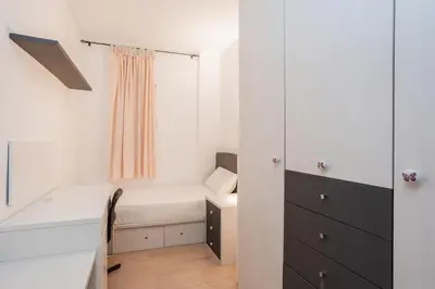 a small bedroom with a bed and a window at Sunny Beachside Haven 2 BD in the Marina District in Barcelona