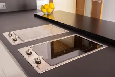 a kitchen counter with a stove with a sink at Sunny Beachside Haven 2 BD in the Marina District in Barcelona