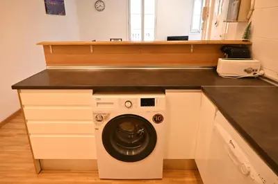 a kitchen with a washing machine under a counter at Homenfun Barcelona Paseo de Gracia in Barcelona