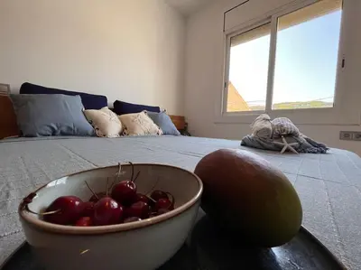 a bowl of fruit on a bed with a bowl of fruit at Apartamento “La Caleta” in Calella