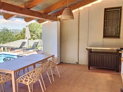 a patio with a table and chairs and a pool at Villa Barcelona en Olivella in Olivella