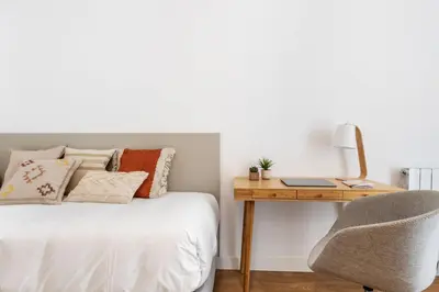 a bedroom with a bed with a desk and a chair at CATERINA Gràcia in Barcelona
