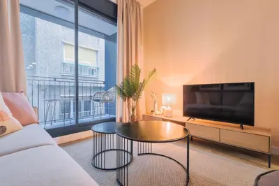 a living room with a couch and a tv and a table at CATERINA Gràcia in Barcelona