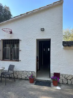 a white building with a door and a basketball hoop at Can Ginesta Muy feliz&tranquilo in Barcelona