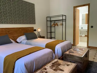 a hotel room with two beds and a table at Ca l'Andreu Teià. Casa modernista in Teià