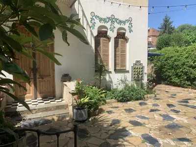 a house with a stone walkway in front of a building at Ca l'Andreu Teià. Casa modernista in Teià
