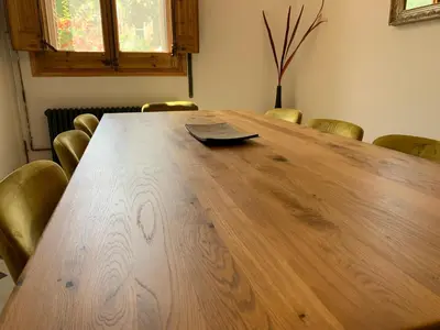 a large wooden table in a room with chairs at Ca l'Andreu Teià. Casa modernista in Teià