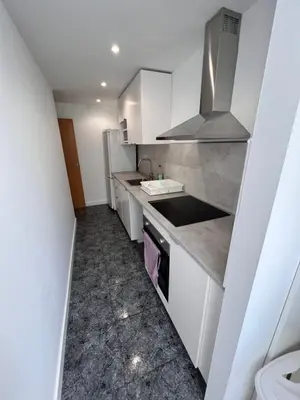 a small kitchen with white cabinets and a sink at Ca La Lidia in Viladecáns