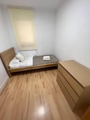 a small room with a bed and a wooden floor at Ca La Lidia in Viladecáns