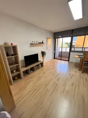 a living room with wooden floors and a flat screen tv at Ca La Lidia in Viladecáns